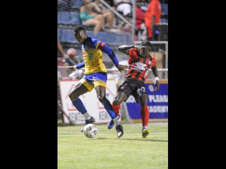 Harbour View’s Ryan Wellington (right) comes under pressure from Arnett Gardens’ Marlon Allen during a Jamaica Premier League (JPL) match at Anthony Spaulding Sports Complex recently. Arnett won the match 3-0.