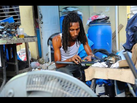 Giovanni Colquhoun, a machine repairman, at his workshop on Shenton Avenue, Portmore, St Catherine, yesterday.