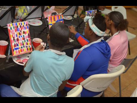 Young women enrolled in the programme for adolescent mothers at the Women’s Centre of Jamaica Foundation participate in the creative art session. Right: Dana Coley, senior associate at PwC Jamaica, delivers the keynote address.