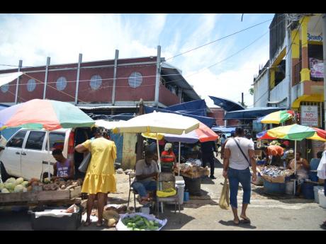 Vendors seek sales for their wares in Linstead, St Catherine, after several stalls went up in flames on June 1.