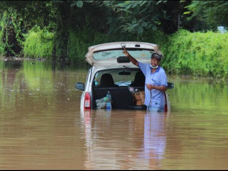 A motorist trapped in floodwaters on Orange Street in Montego Bay, St James, after heavy rainfall.