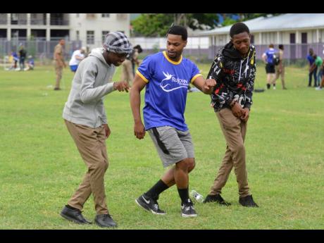  Andrew ‘King Bach’ Bachelor (centre) being taught the ‘Drift’ dance by Kingston College students Javon Johnson (left) and Javaughn Davidson at a RuJohn Foundation empowerment workshop at the school’s Melbourne Park campus yesterday.