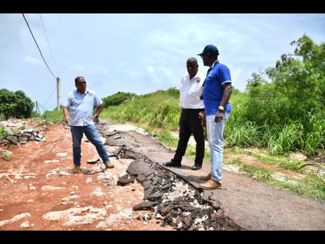 Minister of State in the Ministry of Agriculture, Fisheries and Mining , Franklin Witter (centre), Acting CEO at the Rural Agricultural Development Authority (RADA), Winston Simpson (right) and Acting Parish Agricultural Manager at RADA, St Elizabeth, Mark Lee, examine a farm road in Bull Savannah which was damaged by recent heavy rains.