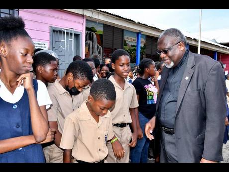 
Custos Rotulorum for St James Bishop Conrad Pitkin (right) interacts with students of Barracks Road Primary School during a devotional exercise at the Corinaldi Primary School in Montego Bay last Friday, in observance of the National Day of Mourning for children who have been victims of violence.