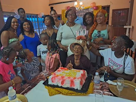 Credit: Rasbert Turner Members of Dowe’s family gather around her during her 100th birthday celebration.