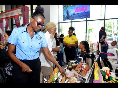 Michelle Smith, representative for the local coffee brand Perk Up, shows some of the different products, during the Christmas in July trade show. 