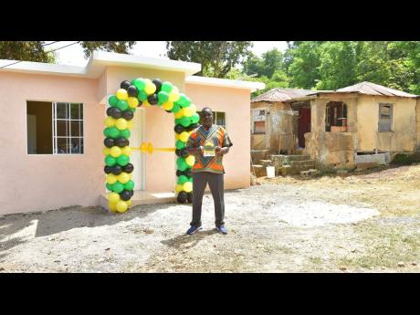 Fitzroy Edwards displays the keys to his new three-bedroom home in Berrydale district in Scott’s Pass, Clarendon. The unit, which was handed over by Prime Minister Andrew Holness, was built under the New Social Housing Programme.  Next to the new house is the dilapidated two bedroom structure in which Edwards lived with his five children.

 