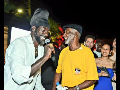 Buju Banton (left) shares a touching moment with his father, Benjamin Myrie, at his earthstrong celebration. 