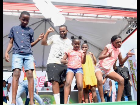 Dancehall artiste TeeJay dances on stage with some young fans to his trending song ‘Drift’ at the Reggae Sumfest Family Funday Community Fest at the Montego Bay Sports Complex, Catherine Hall in Montego Bay on Sunday.