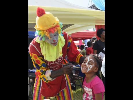 Mark Williams paints the face of little Keliese Cole.