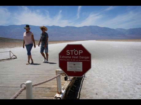 A sign warns visitors of extreme heat danger at Badwater Basin in Death Valley National Park yesterday.