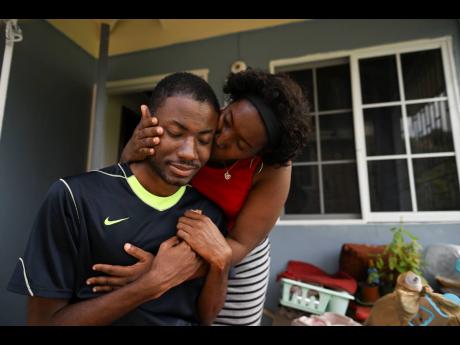 Ramone McKenzie gets a comforting hug and kiss from his mother Vannet at their home in Rock Hall, St Andrew.
