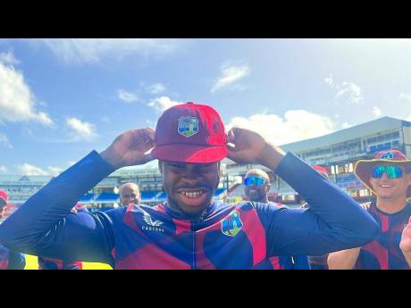 Kirk McKenzie beams with pride while putting on his West Indies Test cap on Thursday before debuting in the second Test against India at Queen’s Park Oval in Trinidad and Tobago.