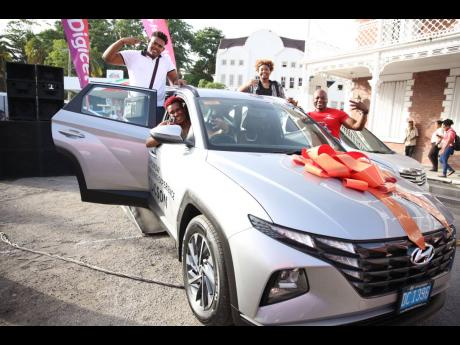 Sherrilee Brown celebrates her new Hyundai SUV alongside her children John-Ross (left) and Jhordann (right) and Digicel’s head of communications and corporate affairs, Elon Parkinson, during the grand handover in Port Antonio, Portland, recently. 