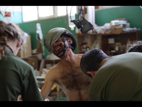 Medics help an injured Ukrainian serviceman in a frontline medical stabilisation point in Zaporizhzhia region, Ukraine on Thursday.  Russia invaded Ukraine last February. The invasion has claimed the lives of tens of thousands of persons on both sides. 