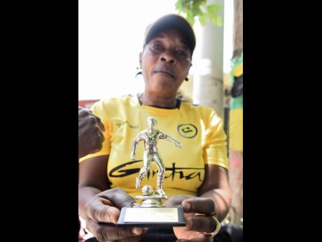 Lucille Hamilton, mother of Reggae Girl Trudi Carter shows off one of the many trophies her daughter has won over the years, prior to joining the Reggae Girlz.