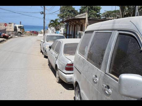 These cars are covered in dust in Shooters Hill, St Andrew.