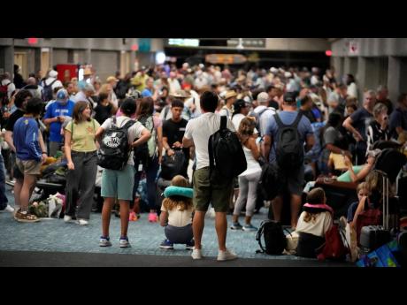 People gather at the Kahului Airport while waiting for flights Wednesday in Kahului, Hawaii. 