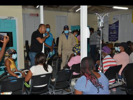 Minister of Health and Wellness Dr Christopher Tufton addresses patients seated in the Accident and Emergency waiting area at the Cornwall Regional Hospital in Mount Salem, St James. 