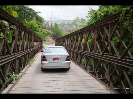 A car traverses the wooden deck of Ramble Bridge in St Thomas.