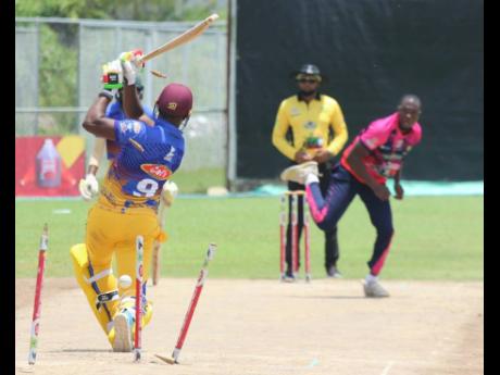 May Pen Lions batsman Mark Williams (left) is comprehensively bowled by Fairfield United and national fast bowler Gordon Bryan (right) during their SDC National T20 play-off encounter at Sir P Oval in Clarendon on Sunday. Fairfield won the match by 47 runs.