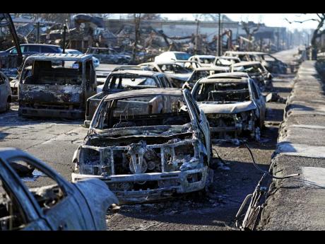 Burnt-out cars line the sea walk after the wildfire.