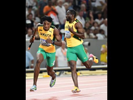 Jamaica’s lead runner, Rusheen McDonald (right), hands the baton to Roshawn Clarke during the final of the men’s 4x400 metres at the World Athletics Championships in Budapest, Hungary, yesterday. Jamaica finished fourth.