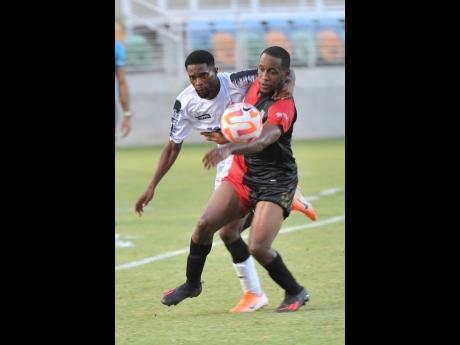 Credit: Nicholas Nunes Cavalier’s Ronaldo Robinson (left) battles with Maurice Ford of the Athletic Club Port-of-Spain for the ball during their Concacaf Caribbean Cup match at Sabina Park on Friday. Cavalier won 2-1.