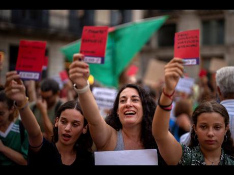 Credit: AP Demonstrators shout slogans during a protest against the president of Spain’s football federation, Luis Rubiales, in Barcelona, Spain, yesterday. Spain face reckoning over sexism in football after the federation head, Rubiales, kissed a player at the Women’s World Cup.