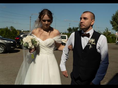 Bride Vladislava Ryabets helps groom Ivan Soroka to walk during their wedding day in Kyiv, Ukraine, on Saturday, September 9.