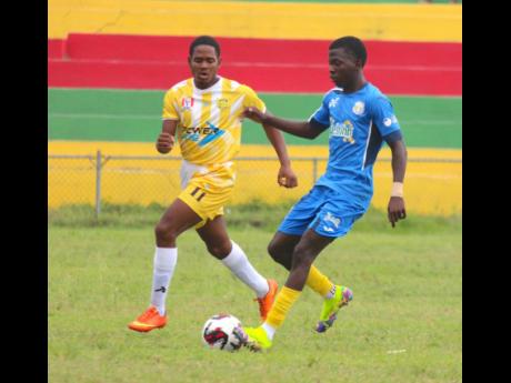 Clarendon College’s Kaheim Dixon (right) tries to go by Claude McKay’s Jevaughn Shaw during their schoolboy ISSA/WATA daCosta Cup football match at Effortville Community Centre on Wednesday. Clarendon won the match 8-0.