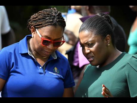 Member of Parliament for St Catherine North East Kerensia Morrison (right) speaks with Senior Superintendent of Police Stephanie Lindsay, head of the Corporate Communications Unit of the Jamaica Constabulary Force. Morrison described the murders as a horror movie.