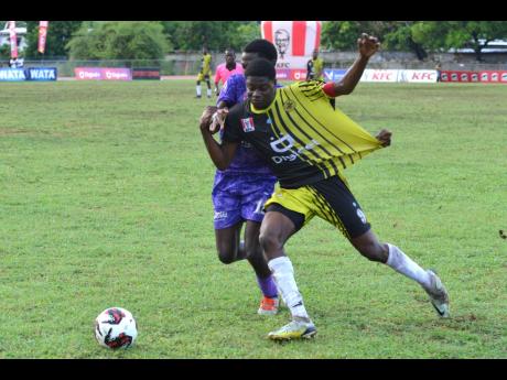 Credit: Kenyon Hemans Kingston College’s Kamaul Patterson (left) hassles Charlie Smith High’s Michael Stoney during their schoolboy ISSA Manning Cup football match yesterday at Calabar High School. Kingston College won the game 1-0.