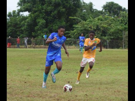 Manning’s School’s Omar Sommerville and Knockalva High’s John Brown chase the ball during their ISSA/WATA daCosta Cup match on Tuesday at the Knockalva Sports Complex in Hanover. Manning’s won 3-1.