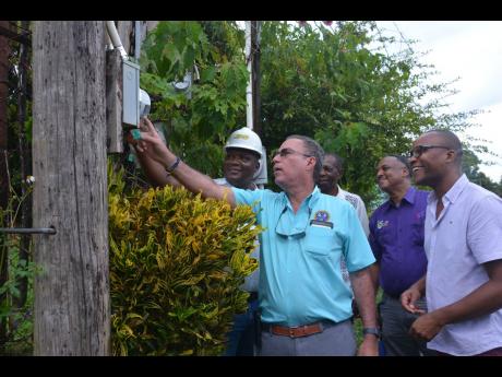 Minister of Science, Energy, Telecommunications and Transport Daryl Vaz (second left)  inspects a Jamaica Public Service (JPS) meter in Prospect, Westmoreland, during a tour of the parish. With Vaz are (from left) Regional Operations Manager, JPS,  David Lewis; State Minister in the Ministry, J.C. Hutchinson; Managing Director, Jamaica Social Investment Fund, Omar Sweeney; and Member of Parliament for Westmoreland Western, Morland Wilson. 