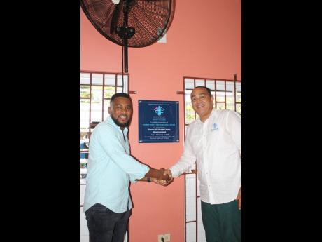 Minister of Health and Wellness, Dr Cristopher Tufton (right), greets donor Kadeen Mairs at the Adopt-a-Clinic ceremony at the Grange Hill Health Centre in Westmoreland last Saturday.