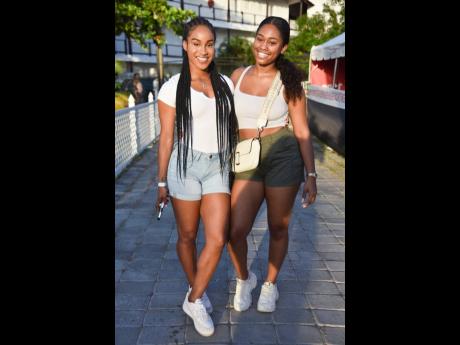 Briana Williams (left) and Chey Swaby enjoying a delightful moment at the Port Royal Seafood Festival on Monday.