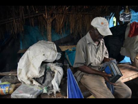 Credit: Nicholas Nunes Harold Moore cleans his old radio, one of the few assets to his name.