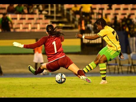 Jamaica’s Christina Salmon (right) shoots at goal, which Guatemala’s goalkeeper Lexia Estrada desperately tries to block.