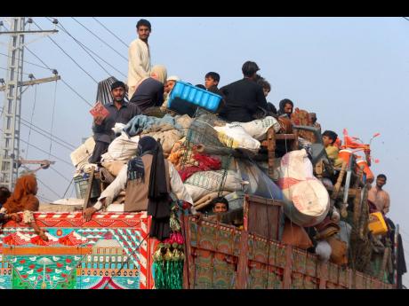 Afghan families onboard a truck as they head towards a border crossing point in Torkham, Pakistan, yesterday. Large numbers of Afghans crammed into trucks and buses in Pakistan, heading to the border to return home hours before the expiration of a Pakistani government deadline for those who are in the country illegally to leave or face deportation.