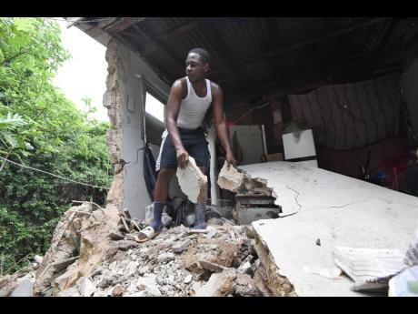 Credit: Ian Allen Christopher Malcolm helps to clear rubble from Penny's home.
