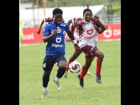 Credit: Ian Allen Jamaica College’s (JC) Jamoy Dennis (left) outruns Eltham High’s Kevin Clarke (right) during their ISSA/Digicel Manning Cup schoolboy football match yesterday at Ashenheim Stadium. JC won 3-1 to advance to the quarter-finals 6-1 on aggregate.