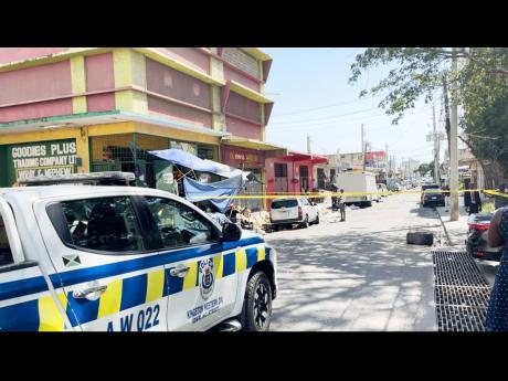 Police cordon the area where two men were shot at their business establishment on Princess Street in downtown Kingston yesterday. 