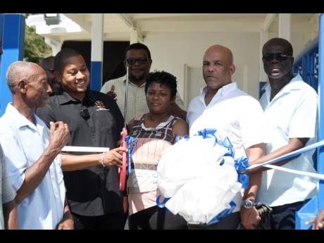 Credit: Kenyon Hemans Minister of Agriculture, Fisheries, and Mining, Floyd Green (second left), cuts the ribbon to open the milking parlour in Hillside, St Thomas, with the assistance of (from left): Harvel Knight; Chairman of the Jamaica Dairy Development Board, Derrick Deslandes; Councillor Caretaker for the Seaforth Division, Sheroo Stephens; Member of Parliament for Western St Thomas, James Robertson; and Chairman of the Rural Agricultural Development Authority St Thomas branch, Dean Jones.