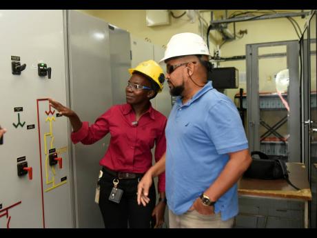 Credit: Kenyon Hemans Waugh chats with Andrew McIntosh, manager of protection system improvement at JPS.