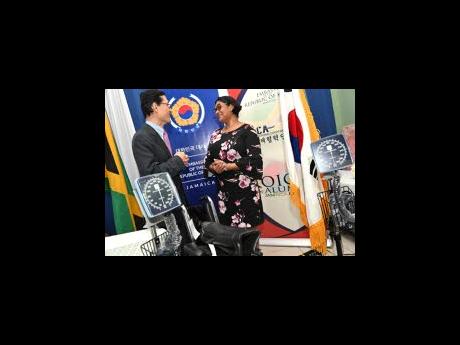 Kim Jinwook (left), chargé d’affaires in the Embassy of the Republic of Korea, chats with Major (ret’d) Dr Susan Wright, assistant regional technical director of the South East Regional Health Authority, after the handover of medical supplies to the Kingston Public Hospital on Tuesday.