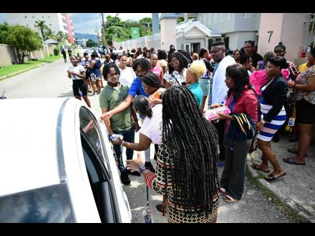Workers in a Corporate Area office head outside after the earthquake on October 30.