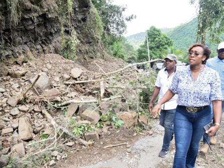 Juliet Holness (right) member of parliament, St Andrew East Rural, and Pearnel Charles jr , minister of labour and social security, look at landslides that blocked sections of Gordon Town to Guava Ridge main road in rural St Andrew. There were nearly 20 landslippages between Gordon Town and Guava Ridge that were linked to the heavy rains last Thursday and Friday. 