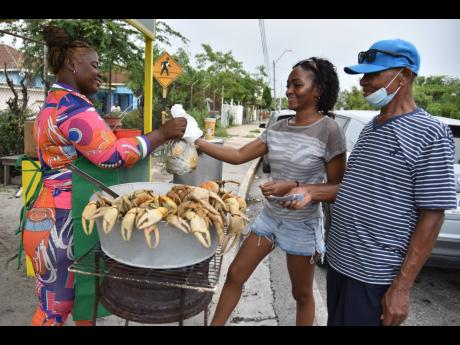 The reopening of Crab Circle was music to the ears of crab lovers Gia Thomas (centre) and George Larnmond, who made a purchase from Abigail Loga.