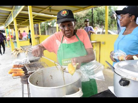 Claudette ‘Babsy’ Reid (left) serves corn to a customer.